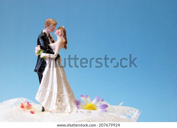 A\
wedding cake topper on top of the newlyweds\
dessert.