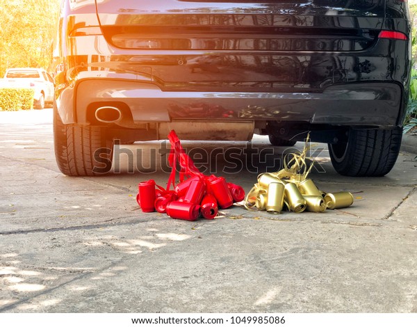 Wedding car\
with red and gold cans tied at the\
back