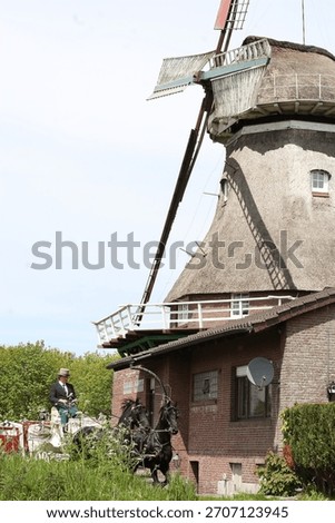 Wedding carriage in front of windmill