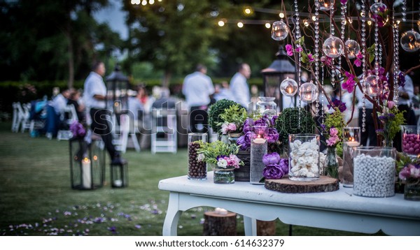 Wedding Ceremony with flowers outside in the\
garden with hanging\
lights