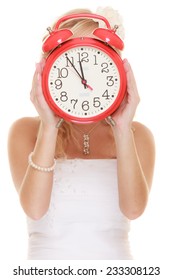 Wedding concept. Time to get married. bride with red alarm clock covering her face isolated