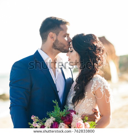 wedding couple. Beautiful bride and groom. Just merried. Close up. Happy bride and groom on their wedding hugging. Groom and Bride on the beach near the sea. wedding dress. 