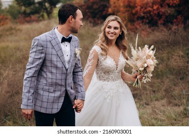 Wedding Couple With Bouquet With Roses And Spikelets .Boho Style In Brides Hands