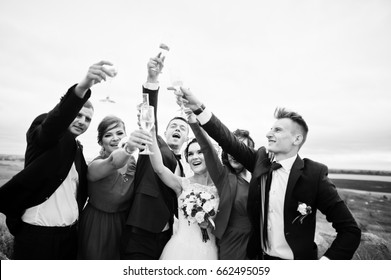 Wedding Couple And Braidsmaids With Groomsmen Drinking Champagne In A Picturesque Countryside. Black And White Photo.