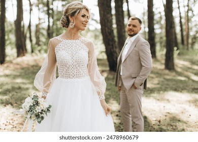 Wedding couple bride and groom walk in pine forest, sunlight filtering through the trees, highlighting their joyful expressions. - Powered by Shutterstock