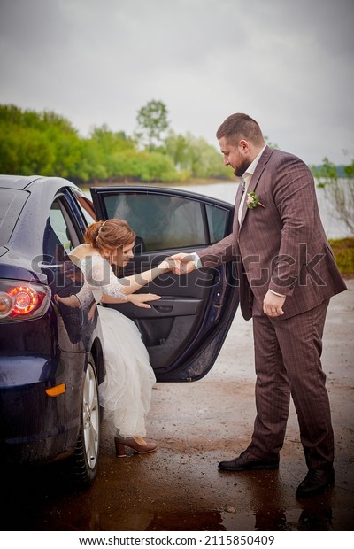 A wedding couple in a car. The bride and groom
in a white dress hug in the
car