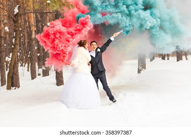 Wedding Couple With Color Smoke In The Winter Park. Colour Bomb