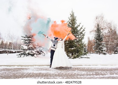 Wedding Couple With Color Smoke In The Winter Park. Colour Bomb