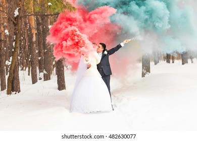 Wedding Couple With Color Smoke In The Winter Park. Colour Bomb