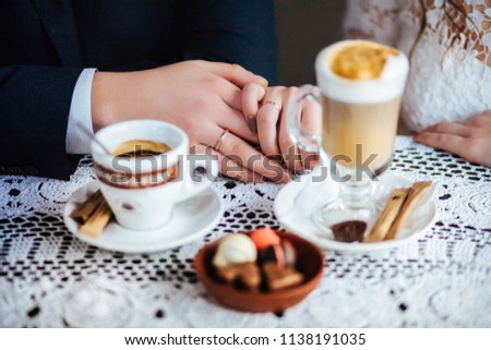 Wedding couple drink coffee and holding hands. Wedding card