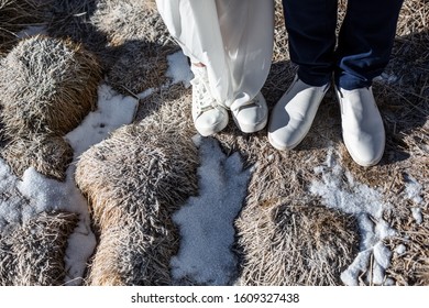 Wedding Couple Feet Standing On Frost  Grass. Frozen Winter Morning