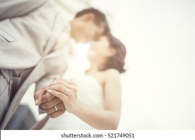 Wedding Couple Holding Hands On Sunset Background.Soft Focus