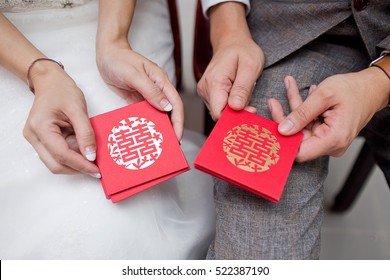 Wedding couple holding red envelope packet / hongbao. Chinese Wedding with Double Happiness Text Calligraphy Illustration on red packet.
