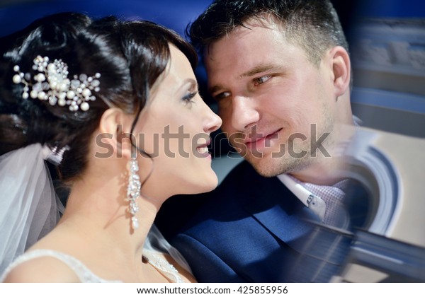 Wedding
couple is hugging in a car. Beauty bride with groom. Beautiful
model girl in white dress. Man in suit. Female and male portrait.
Woman with lace veil. Cute lady and guy
outdoors
