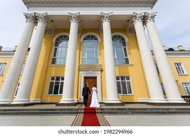 Wedding Couple On The Background Of A Large House With Columns