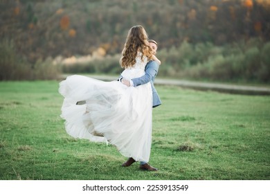 Wedding couple on the nature is hugging each other. Beautiful model girl in white dress. Man in suit - Shutterstock ID 2253913549