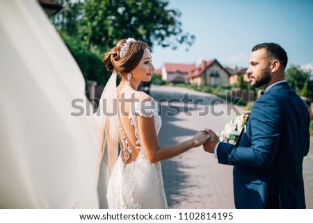 Wedding couple on the nature is walking. Beautiful model girl in white dress. Handsome man in suit. Beauty bride with groom. Female and male portrait. Lady and guy outdoors
