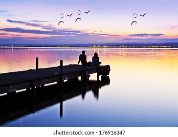 wedding couple on the pier watching the sunrise