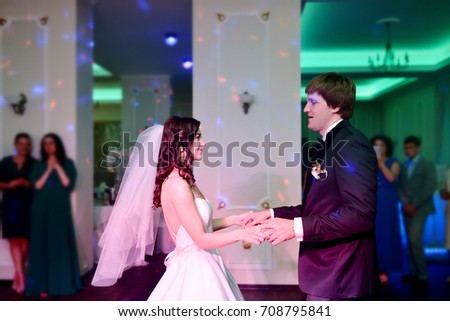 Wedding couple in the restaurant is dancing. Beautiful model girl in white dress. Handsome man in suit. Beauty bride with groom. Female and male portrait. Woman with lace veil. Lady and guy indoors