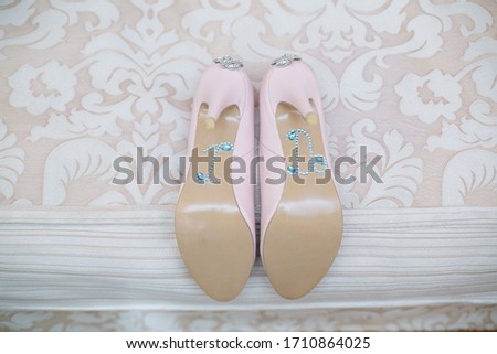 wedding day. wedding background. wedding details and accessory. pink bridal high heels shoes decorated with shiny rhinestones and stones close up. women's shoes decorated the inscription " I do" 