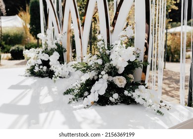 Wedding Day Decor, On A White Background Of The Wedding Arch Is A Composition Includes Orchids, Roses And Boxwood