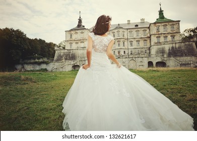 Wedding day. Gorgeous  bride walking next to castle in west Ukraine.