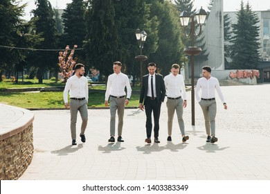 Wedding. Wedding day. Groom with groomsmen walking after wedding ceremony. Handshakes. Groom with friends at wedding day 