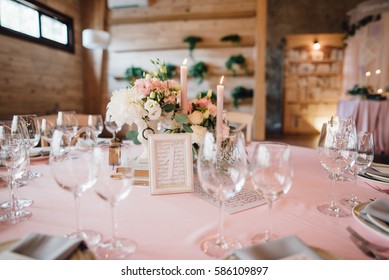 Wedding decor. Reception table number 1 in photo frame. Composition of pink and white roses with greenery, candles and books. Provence style. 