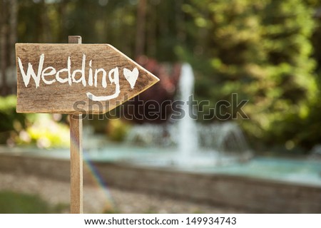 Wedding decor. Wooden plaque with the inscription Wedding. Wedding on a plate green background and a fountain. Wedding decorations,