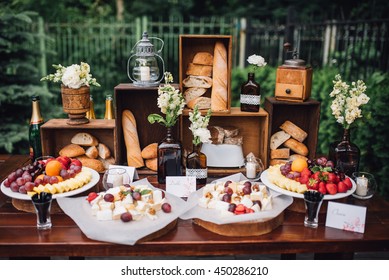 Wedding decorations. Reception. Buffet. Fruits and cheese on plates with bread in boxes. Food bar decorated by flowers and lanters