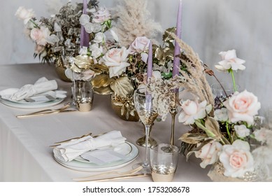 wedding decorations. Served wedding table with decorative  fresh fresh flowers and dried flowers. celebration details. flower composition roses plates and candles in candlesticks