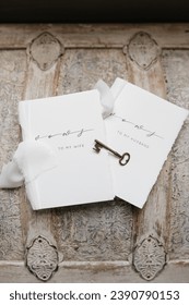 Wedding detail photo of husband and wife vow books on a vintage wooden chest