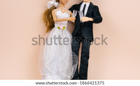 wedding dolls bride and groom with wine glasses on a beige background