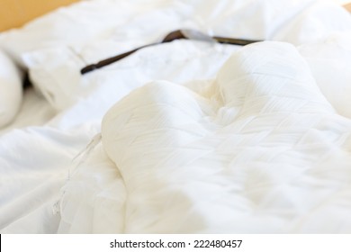 Wedding Dress With Hanger Laying On The Bed.