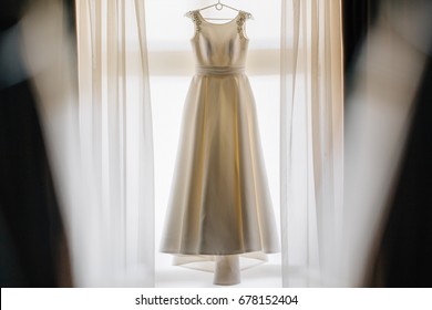 Wedding Dress On Hanger On A Wall. Beautiful Gown