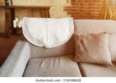 Wedding Dress In White Hanging Garment Bag On The Back Of The Couch. The Morning Before The Wedding.