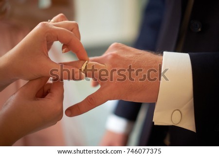 wedding, dressing wedding ring on finger close-up