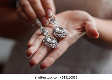 Wedding Earrings On A Bridal Hand, Bride's Morning And Jewelry Accessories And Decoration Concept