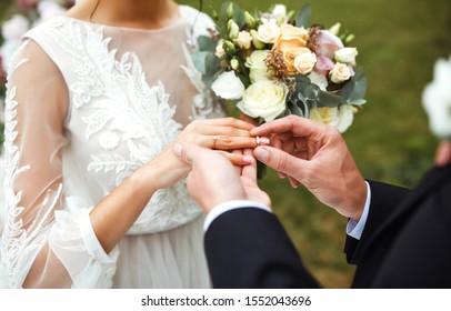 Wedding engagement rings. Married couple exchange wedding rings at a wedding ceremony. Groom put a ring on finger of his lovely wife. Concept wedding details. Happy family. Together.