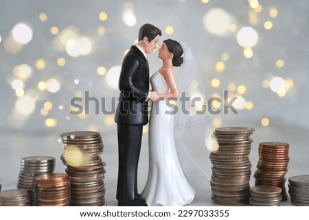 Wedding expenses concept - bride and groom with stacks of coin money