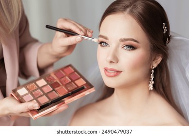 Wedding Eyeshadow Palette. Makeup Artist doing Bridal Make up applying Shadow. Beautiful Bride preparation. Wedding Salon - Powered by Shutterstock