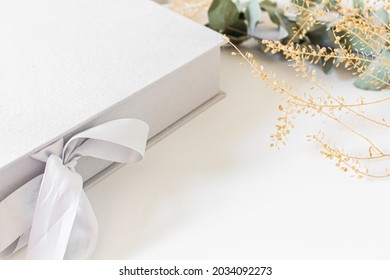 Wedding Or Family Photo Album On A Light Grey Box, Eucalyptus Branches And Leaves Isolated On White Background. Flat Lay, Top View,