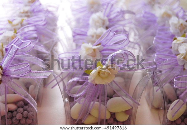 Wedding favors. Boxes with purple ribbon\
containing confetti and\
candies.