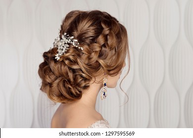 Wedding female hairstyle low beam on the head of a brown-haired girl back view on a light background. - Powered by Shutterstock