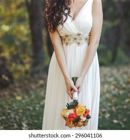 Wedding In Forest. Bride Wearing Simple Wed Dress, Holding Bouquet. 