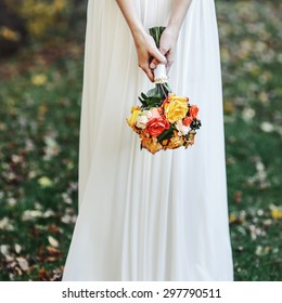 Wedding In Forest. Bride Wearing Simple Wed Dress, Holding Bouquet. 