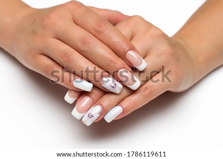 Wedding french white manicure with white painted flower on a white background close-up on long square nails. Gel design.