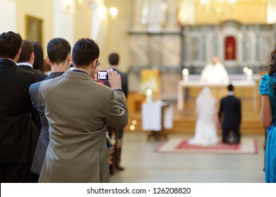 Wedding Guest Taking Photos On A Wedding Ceremony