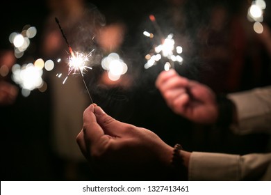 Wedding guests during the evening wedding ceremony holding sparklers