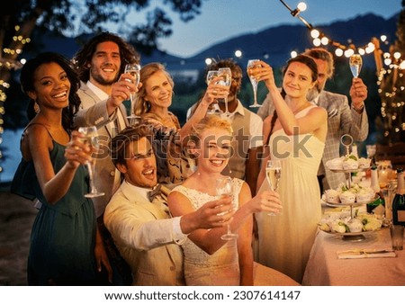 Wedding guests toasting champagne during wedding reception in garden